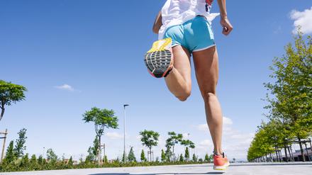  Legs of mid adult woman running on road against blue sky during sunny day model released Symbolfoto JCMF01151