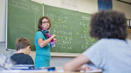 Lehrerin unterrichtet Mathematik in einer Klasse. Symbolbild