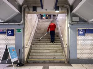 Hart verdientes Geld: Eine Reinigungskraft kehrt in einem Bahnhof einen Treppenaufgang.