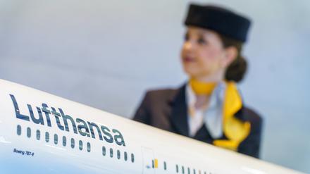 Eine Flugbegleiterin steht hinter einem Modell einer Lufthansamaschine. Bei der Lufthansa ist für das Kabinenpersonal als letzte große Beschäftigtengruppe eine Tarifeinigung erreicht worden. 