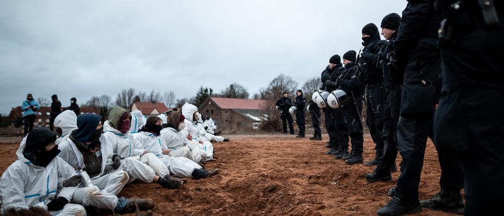 Polizisten beobachten eine Blockade durch Umweltaktivisten vor dem Braunkohletagebau in Lützerath. 