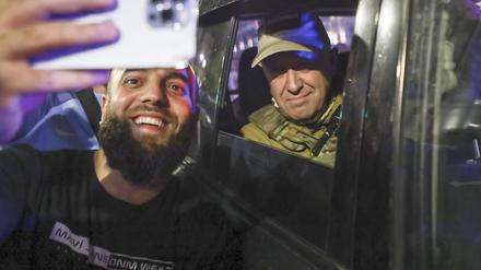 Jewgeni Prigoschin (r), Eigentümer des Militärunternehmens Wagner Group, sitzt in einem Militärfahrzeug und macht ein Selfie mit einem Zivilisten auf einer Straße in Rostow am Don.