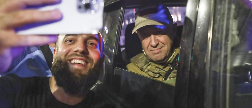Jewgeni Prigoschin (r), Eigentümer des Militärunternehmens Wagner Group, sitzt in einem Militärfahrzeug und macht ein Selfie mit einem Zivilisten auf einer Straße in Rostow am Don.