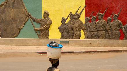 Eine Frau geht in Bamako in Mali an einem Denkmal der Armee vorbei.