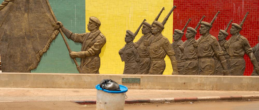 Eine Frau geht in Bamako in Mali an einem Denkmal der Armee vorbei.