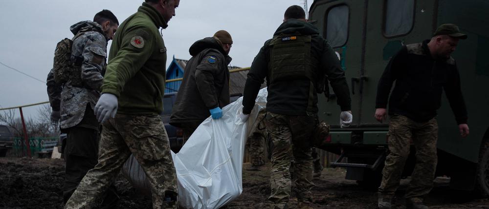 Ukrainische Militärärzte tragen einen toten Soldaten