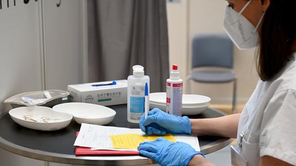 Eine Ärztin füllt eine Impfbescheinigung aus. Ab Februar müssen die Beschäftigten in Arztpraxen und anderen ambulanten medizinischen Einrichtungen in Baden-Württemberg keine Masken mehr tragen. 