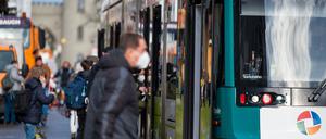 Ein Fahrgast steigt mit einer FFP2-Maske in eine Straßenbahn in Potsdam ein.