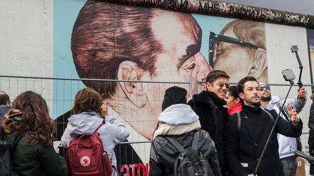 Touristen fotografieren sich selbst vor dem berühmten Bild „The Kiss“ an der East Side Gallery in Berlin-Friedrichshain.