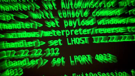 Buchstaben und Zahlen leuchten auf einem Bildschirm, auf dem ein Hacker-Programm geöffnet ist. 