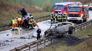 Ein ausgebrannter PKW und ein weiteres verunfalltes Fahrzeug stehen an der Unfallstelle auf der B247 bei Bad Langensalza. 