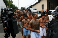 Mitglieder der Gang Mara Salvatrucha in El Salvador werden von Polizisten ins Gefängnis begleitet.