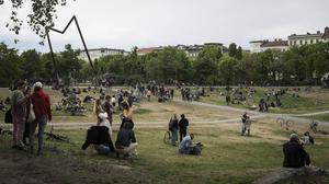  Menschen sitzen am 1. Mai 2020 in kleinen Gruppen auf einer Wiese im Görlitzer Park in Berlin Kreuzberg. Aufgrund der Corona Pandemie sind alle Demonstrationen und Großveranstaltungen zum 1. Mai abgesagt. Foto: bildgehege Automat für Schutzmasken