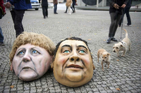 Masken von Angela Merkel und Sigmar Gabriel vor dem Bundestag bei einer Protestaktion.