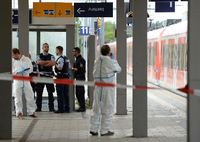 Polizisten stehen am am Bahnhof in Grafing bei München auf dem Bahnhof und nehmen ihre Ermittlungen auf.