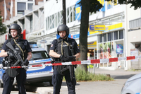 Einsatzkräfte der Polizei sperren am Freitag nach einer Messerattacke in einem Supermarkt in Hamburg den Tatort ab.