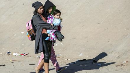 Eine Mutter trägt ihr Kind, nachdem sie den Rio Grande überquert hat, um in die USA einzureisen. 