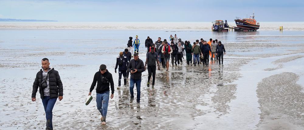 Eine Gruppe von Migranten geht an Land.