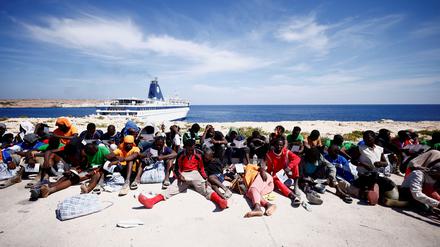 Migranten warten in der Nähe des Hafens auf der sizilianischen Insel Lampedusa auf ihre Überführung zum Festland, Italien, 14. September 2023. 