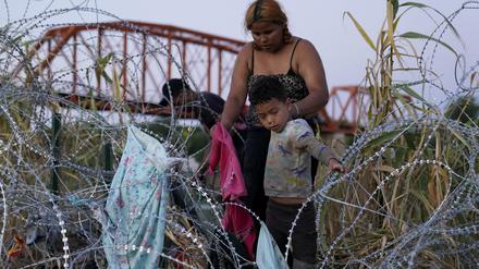 Migranten klettern über den Stacheldraht, nachdem sie den Rio Grande überquert und die USA von Mexiko aus betreten haben.