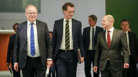 Bundeskanzler Olaf Scholz (r, SPD), Stephan Weil (SPD, l), Ministerpräsident von Niedersachsen, und Hendrik Wüst (CDU), Ministerpräsident von Nordrhein-Westfalen, kommen nach der Ministerpräsidentenkonferenz zur Pressekonferenz.