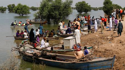 Durch die Überschwemmungen aus ihren Häusern vertriebene werden mit Booten transportiert.
