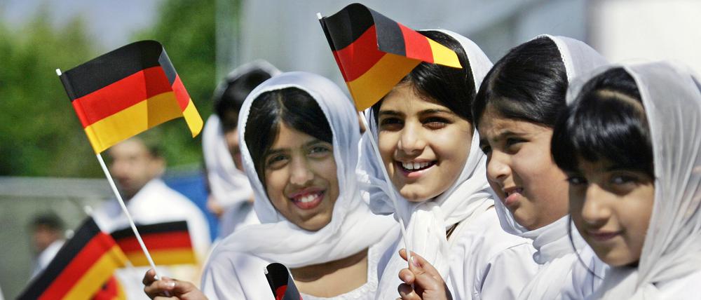 Muslimische Mädchen schwenken auf einer Jahresversammlung der muslimischen Reformgemeinde Ahmadiyya in Mannheim deutsche Fahnen.