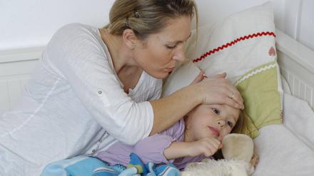 Eine Mutter kümmert sich um ihre kranke Tochter.
