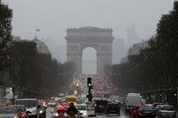 Autos fahren in Paris auf der Avenue des Champs-Élysées auf den Arc de Triomphe zu.