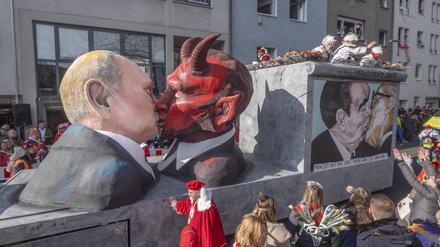 Die Koelner Persiflagewagen nehmen das Weltgeschehen satirisch aufs Korn. Sie zeigen etwa den russischen Praesidenten Wladimir Putin bei einem Kuss mit dem Teufel Foto.