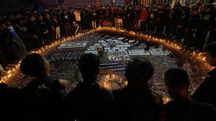 Anhänger des Fußballvereins Arema FC stehen um ein Herz aus Kerzen und beten für die Opfer der tödlichen Massenpanik bei einem Fußballspiel am 01.10.2022.