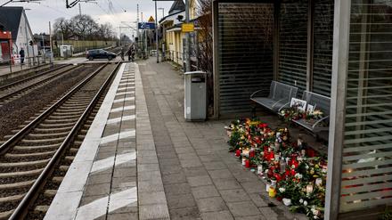 Blumen, Kerzen und verschiedene Bilder sind im Wartehäuschen am Bahnhof Brokstedt zum Gedenken an die Opfer der Messerattacke niedergelegt.