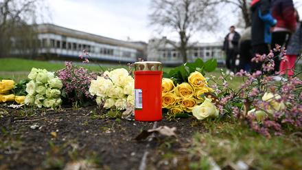 Blumen und eine Kerze als Zeichen der Anteilnahme wurden auf einer Wiese vor einem Schulzentrum in der Nähe des Tatortes niedergelegt.