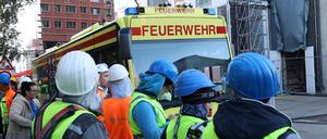 Einsatzfahrzeuge der Feuerwehr und Bauarbeiter stehen vor einer Baustelle. Nach dem schweren Unfall auf einer Großbaustelle in der Hamburger Hafencity ist ein fünfter Bauarbeiter gestorben. (Archivfoto)
