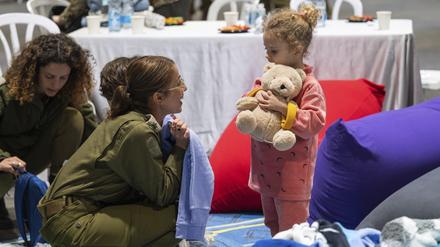 Die dreijährige Yahel bei ihrer Ankunft in Israel nach ihrer Freilassung spielt mit einer israelischen Soldatin.