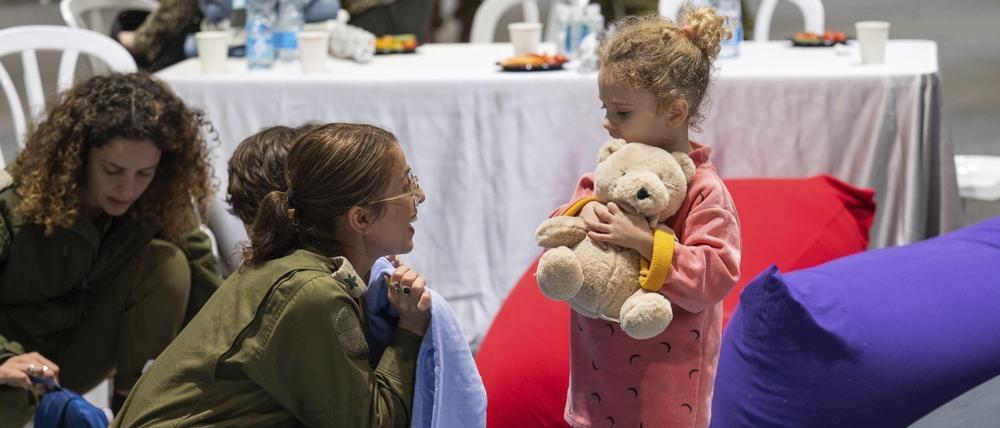 Die dreijährige Yahel bei ihrer Ankunft in Israel nach ihrer Freilassung spielt mit einer israelischen Soldatin.