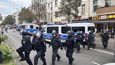 Polizisten laufen angesichts möglicher propalästinensischer Proteste in Berlin-Neukölln über die Straße.