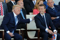 Der französische Präsident Emmanuel Macron (r) lacht mit US-Präsident Donald Trump während der Parade auf dem Champs Elysees.