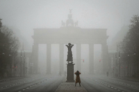 Eine Passantin fotografiert im Nebel das Brandenburger Tor.