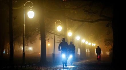 31.10.2022, Berlin: Radfahrer fahren am Abend durch den nebeligen Tiergarten. Foto: Kay Nietfeld/dpa +++ dpa-Bildfunk +++