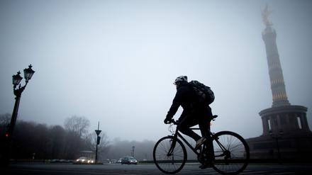 Ein Mann fährt am 23.11.2012 im Nebel an der Siegesäule in Berlin vorbei. Foto: Kay Nietfeld/dpa +++(c) dpa - Bildfunk+++