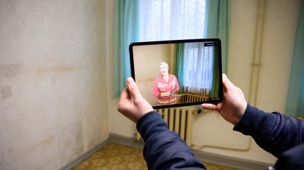 Projektmitarbeiter Stefan Marx zeigt, wie auf einem Tablet-Computer eine frühere Gefangene von ihren Erinnerungen erzählt.