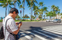 Das könnte teuer werden: Ein Fußgänger mit einem Mobiltelefon auf einem Zebrastreifen in Honolulu.