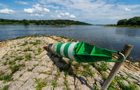 Eine sogenannte Tonne für die Schifffahrt liegt auf einer Steinbuhne am Ufer der Elbe.