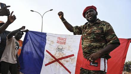 Anhänger des Nigers National Council of Protection of the Homeland (CNSP) zeigen bei einem Protest vor dem französischen Luftwaffenstützpunkt Niamey eine französische Nationalflagge mit einem X-Zeichen.