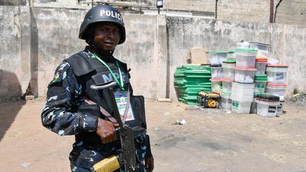 TOPSHOT - An anti riot Police officer stands meters away from ballot boxes used during the presidential elections at the state headquarters of Independent National Electoral Commission (INEC) in Yola on February 26, 2023 the day after Nigeria's presidential and general election. (Photo by PIUS UTOMI EKPEI / AFP)