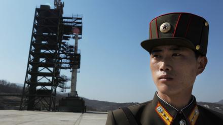 Ein nordkoreanischer Soldat steht vor einer Unha-3 Rakete an einer Abschussrampe an der Westküste Nordkoreas.