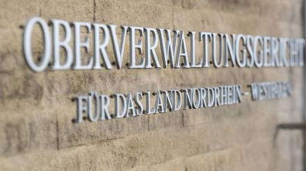 An der Außenfassade steht auf einem Schild der Schriftzug: „Oberverwaltungsgericht für das Land Nordrhein-Westfalen“. 