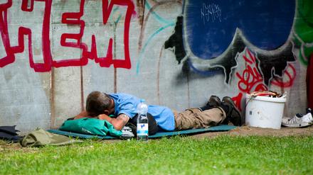 Ein Obdachloser schläft am Bahnhof Zoo.
