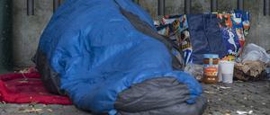 Ein Obdachloser liegt in Berlin in einen Schlafsack gehüllt unter einem Dachvorsprung vor dem Zoo. (Symbolfoto)